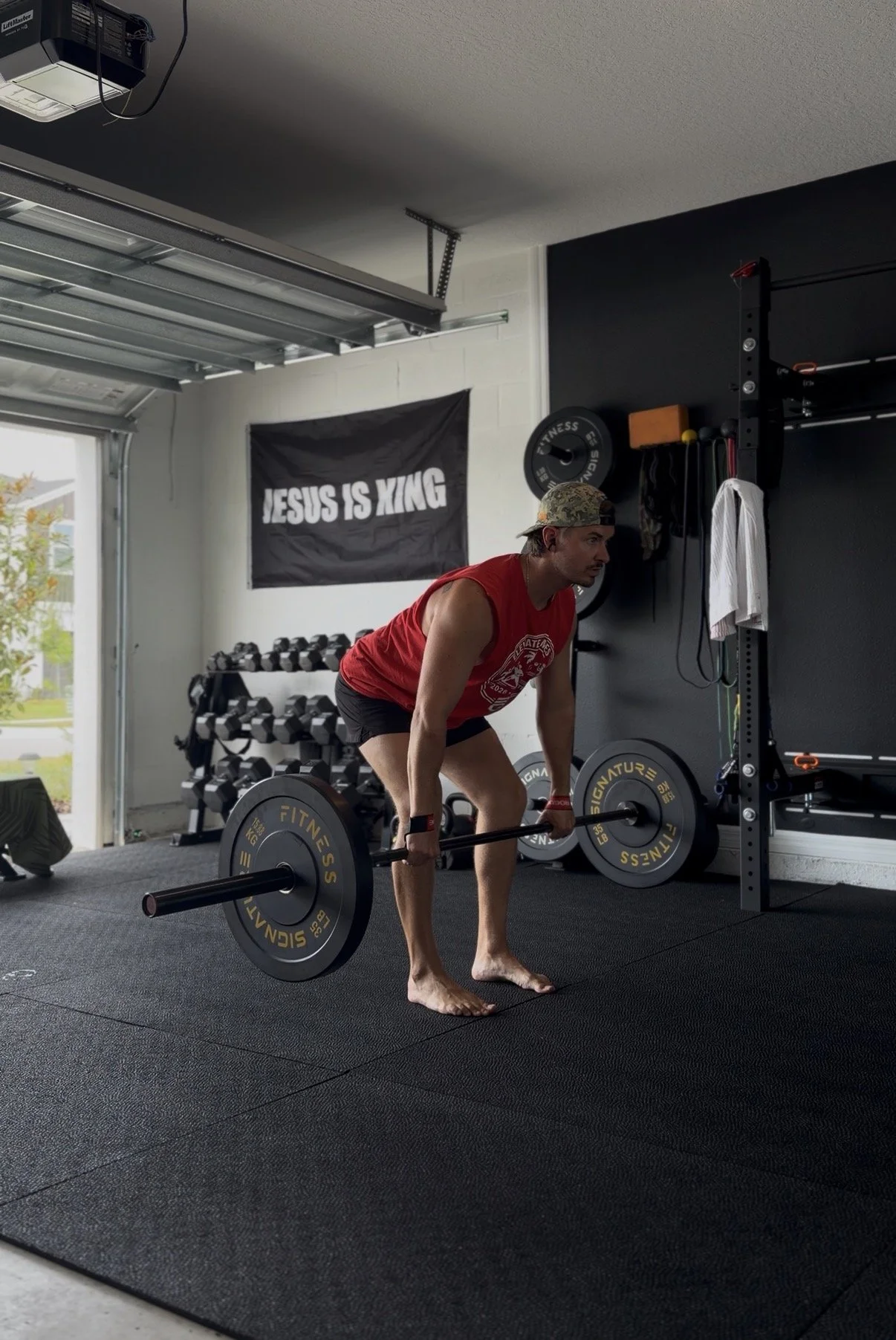 Mitch setting up for a deadlift in his garage gym with the door open